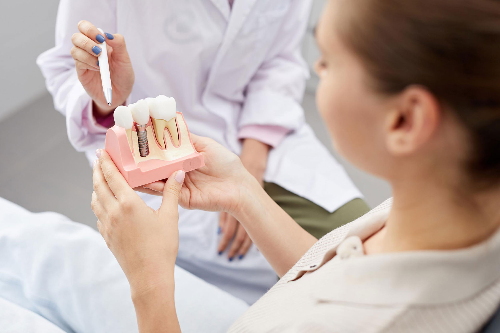 Zahnarzt demonstriert an Zahnmodell